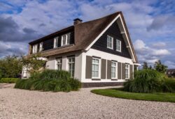 Woning met rieten kap en donkere houten gevelbekleding